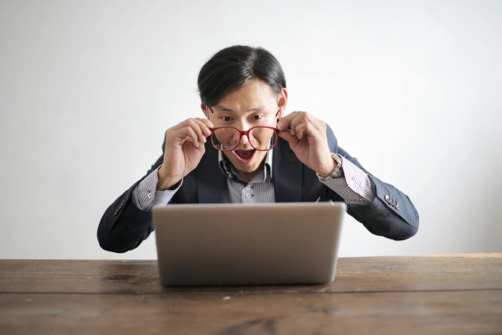 Photo by Andrea Piacquadio - Advertising Raleigh Surprised man in a suit looking at laptop, expressing disbelief indoors.